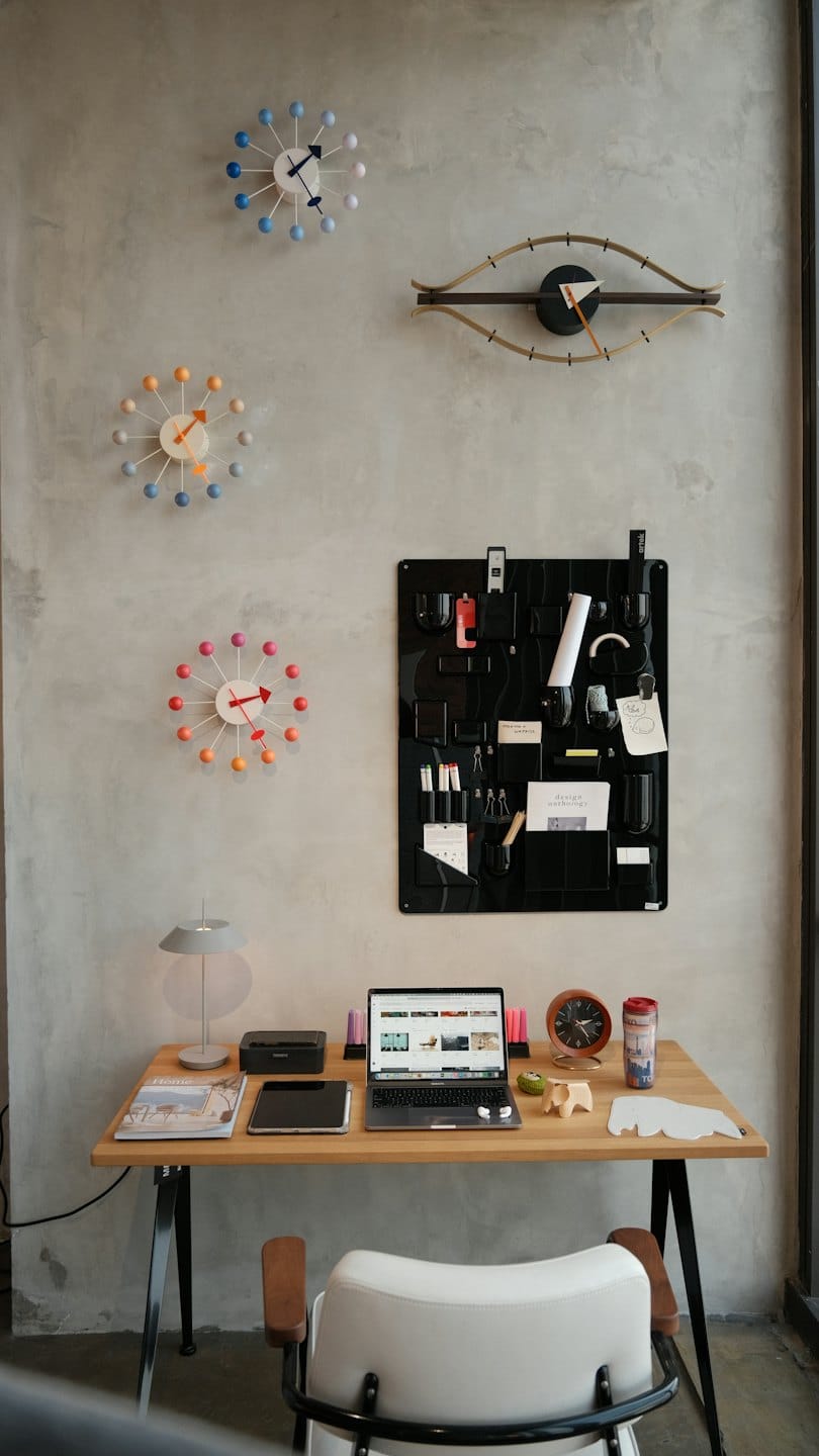 Ufficio moderno con laptop e orologi a muro.
