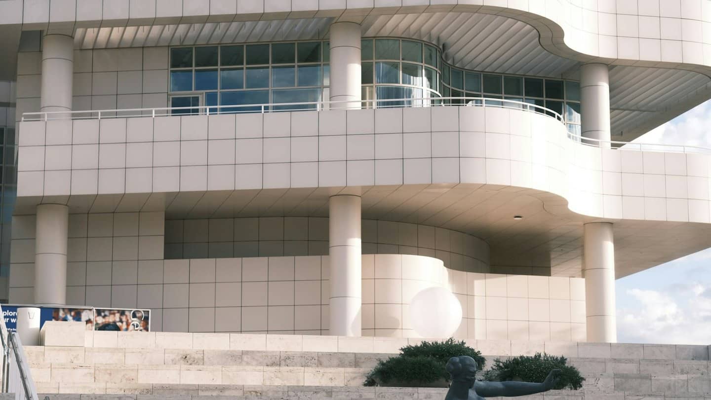 Edificio moderno con livelli piastrellati bianchi e finestre di vetro.